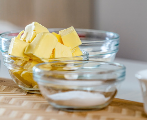 Butter in a bowl with another bowl with sugar in front